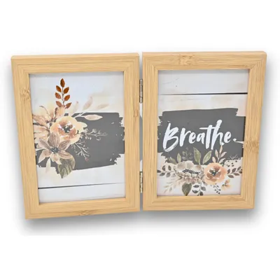 A double photo frame made of wood, with two pictures inside, one with flowers and the other with the word "Breathe" and flowers.