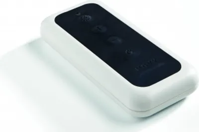 A white remote control with a black panel and buttons, placed on a white surface with a shadow.