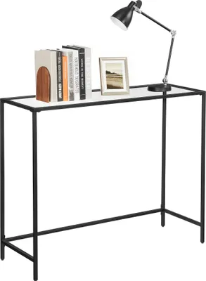 A console table with books, a picture frame, and a desk lamp on top, set against a white background.