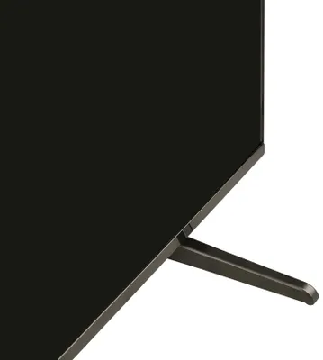 A close-up view of the bottom corner of a black television set, showing its stand.