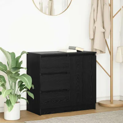 A black sideboard with drawers and a cabinet door is shown in a room with a plant and a coat rack.