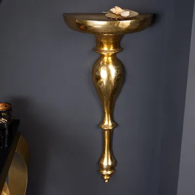 A gold-colored wall console is mounted on a dark gray wall.