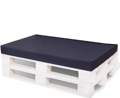 A dark blue cushion placed on a white wooden pallet.