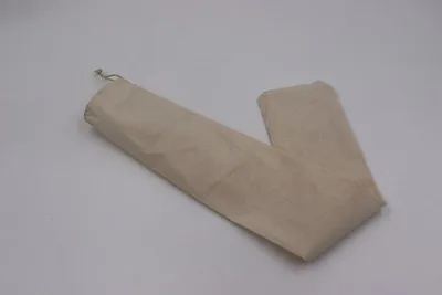 A beige fabric sleeve for a rolling pin lies on a light gray surface.