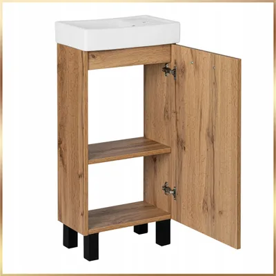 A bathroom vanity cabinet with a sink on top and an open door revealing shelves.