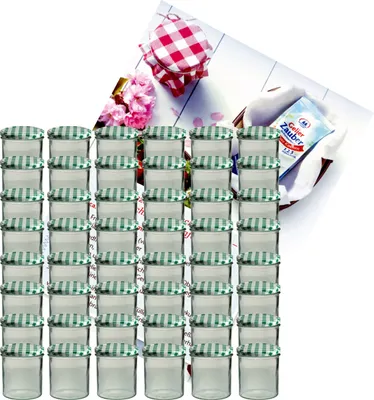 A collection of small glass jars with green and white checkered lids, arranged in stacks, with a decorative background featuring flowers and a recipe booklet.