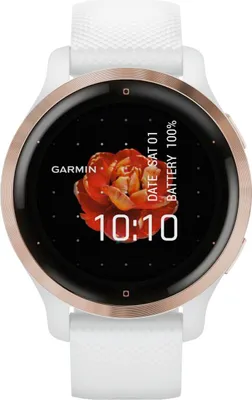 A close-up front view of a Garmin smartwatch with a white band and rose gold bezel, displaying the time and date on its screen.