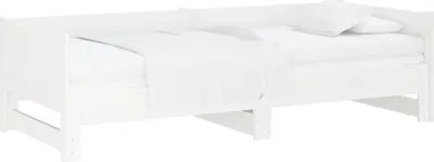 A white wooden daybed with white bedding and pillows.