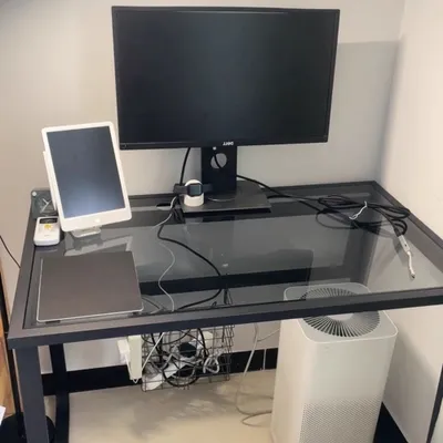 A desk setup with a computer monitor, tablet, and air purifier.