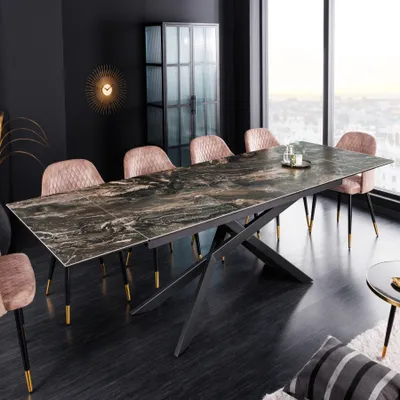 A modern dining room with a large extendable table and chairs, set against a window with a city view.