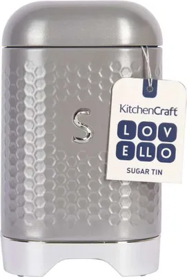 A grey sugar tin with a textured surface and a white tag attached.