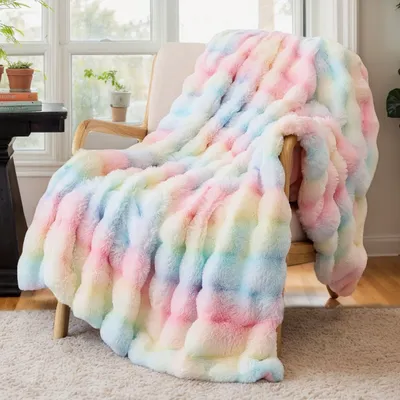 A soft, colorful blanket draped over a chair in a room with a window.