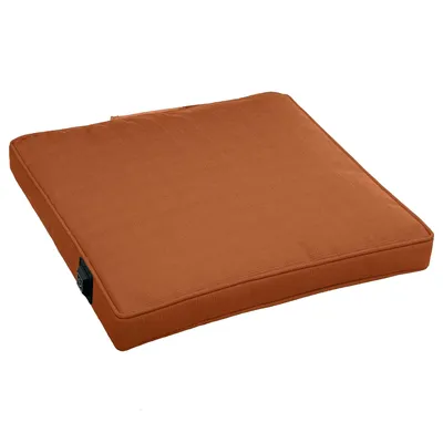 A single, square, terracotta-colored seat cushion is shown from a slightly elevated side angle against a white background.
