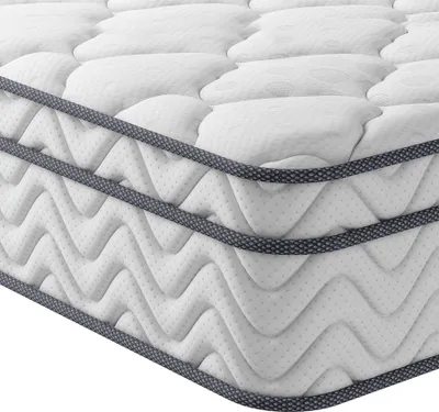 A close-up, angled view of a white mattress with a quilted pattern and dark gray piping along the edges.