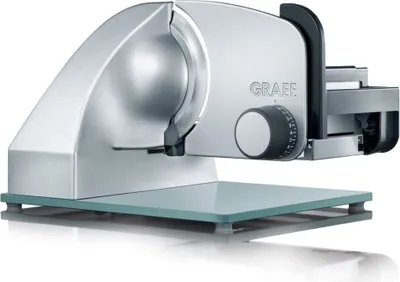 A silver electric slicer on a glass base.