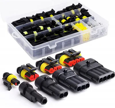 A set of electrical connectors in a clear plastic organizer box, with some connectors laid out in front of the box.