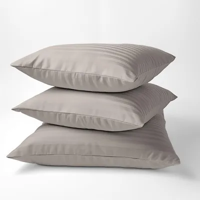 Three beige striped pillows are stacked on top of each other against a white background.
