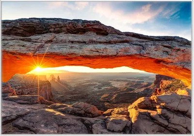 Produktbild von Wallario Wandbild Sonnenstrahl am Horizont  Leuchtende Felsspalte, Größe: 70,30 x 100,30 cm, Poster mit weißem Kunststoffrahmen