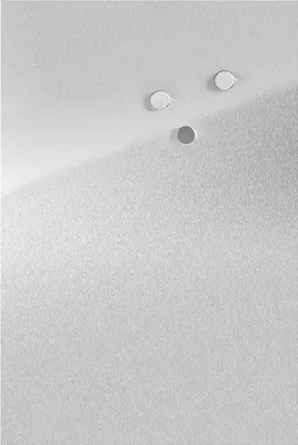 A close-up view of a metallic surface with three circular magnets attached.