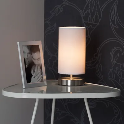 A table lamp and a framed photo are placed on a small table.
