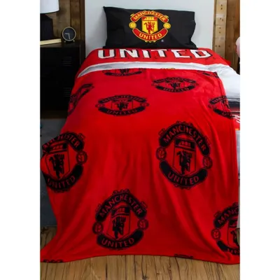 A bed with Manchester United themed bedding.