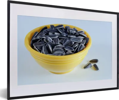 Produktbild von MuchoWow® MuchoWow® Gerahmtes Poster Sonnenblumenkerne in einer gelben Schale mit ein paar heruntergefallenen Sonnenblumenkernen 60x40 cm - Poster mit zchwarzem Bilderrahmen - Schlafzimmer - Plakat in