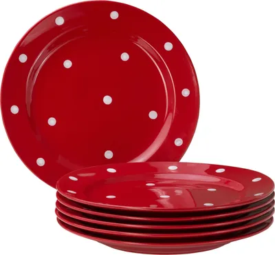 A stack of red plates with white polka dots, with one plate prominently displayed on top.