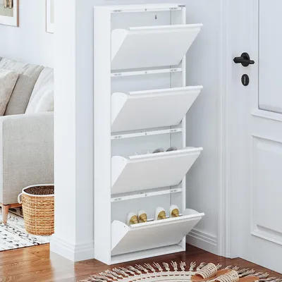 A white shoe cabinet with four flip-down compartments is shown in a room next to a doorway.