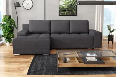 A modern living room with a sectional sofa, coffee table, and plants.