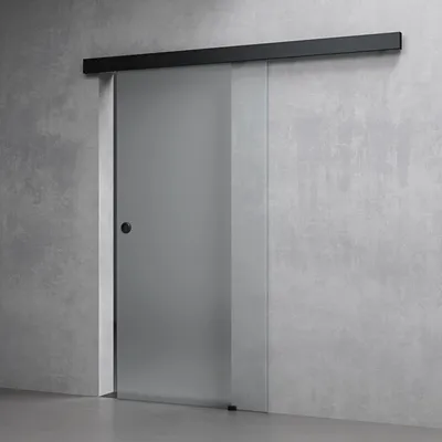 A frosted glass sliding door with a black handle and track against a concrete wall.