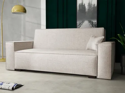 A sofa in a room with a lamp and artwork.