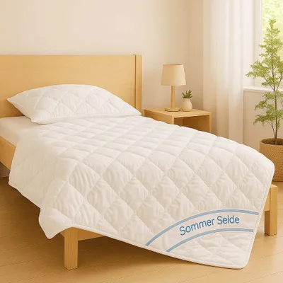 A white quilted blanket and pillow are laid out on a wooden bed frame, with a bedside table and a plant in the background.