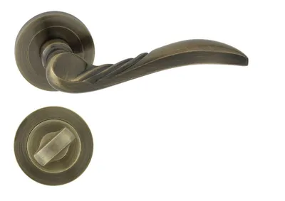 Produktbild von Domino Türgriff-Set "DALIA" mit runder Rosette – Bad/WC Verriegelung – Messing Antik – Rustikaler Badezimmer-Türbeschlag im Retro-Stil