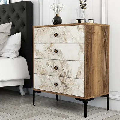 A chest of drawers with a marble-effect front and wooden sides, placed next to a bed in a bedroom setting.