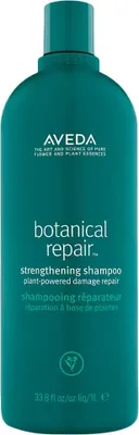 A teal bottle of Aveda Botanical Repair Strengthening Shampoo.