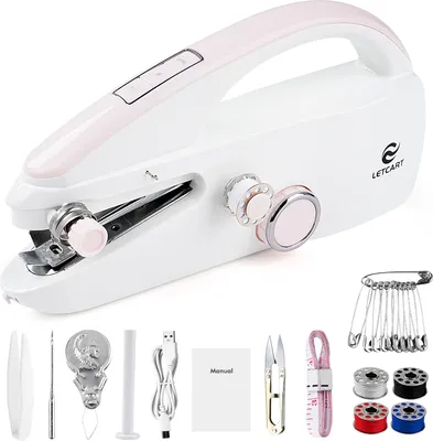 A white and pink mini sewing machine with various accessories laid out around it.