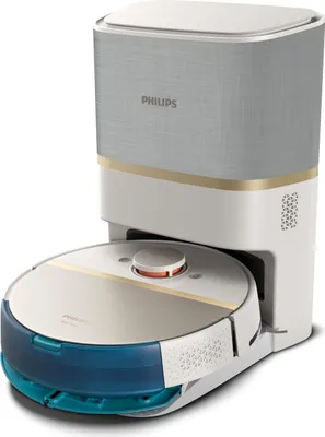 A white and gold robot vacuum cleaner docked in its charging station.