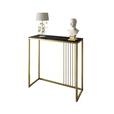 A console table with a black glass top and gold metal frame, decorated with a lamp and a bust.