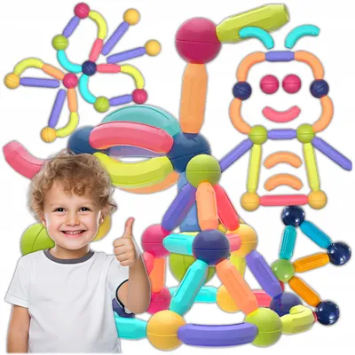 A young child gives a thumbs-up next to a collection of colorful magnetic building blocks.