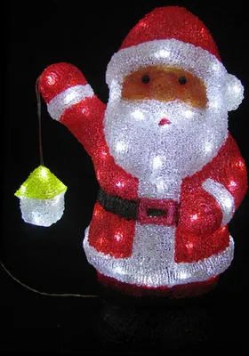 A decorative LED Santa Claus figure holding a lantern against a black background.