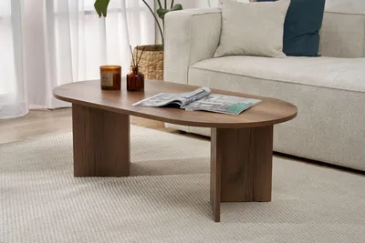 A living room scene with a coffee table in the foreground and a sofa in the background.