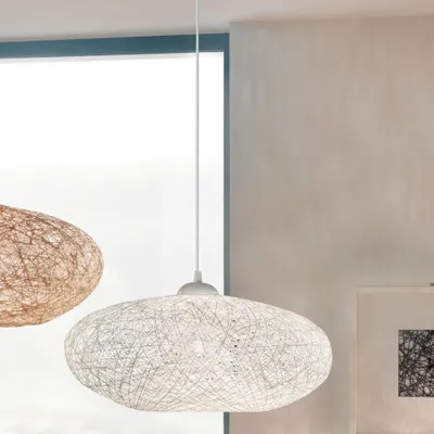 Two pendant lamps hanging in a room with a window and a framed picture on the wall.