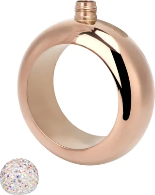 A rose gold colored flask shaped like a bracelet with a decorative cap next to it.