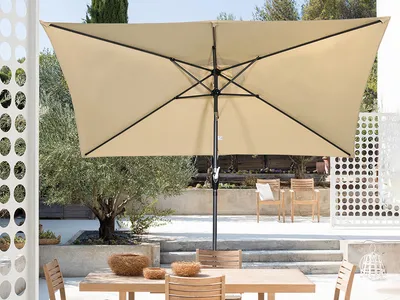 An outdoor patio scene with a rectangular umbrella over a table and chairs.