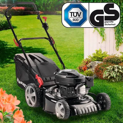 A black BRAST Benzin Rasenmäher 18170 ECO lawnmower is shown on a green lawn, with decorative plants and rocks in the background. Two certification logos are visible in the top right corner.