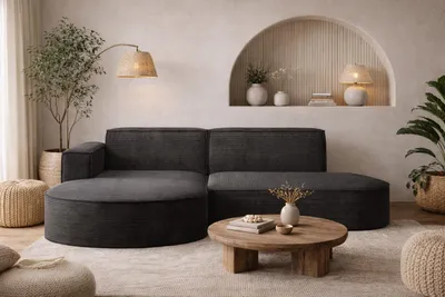 A modern living room scene featuring a dark gray sectional sofa with rounded ends, a wooden coffee table, and decorative elements.