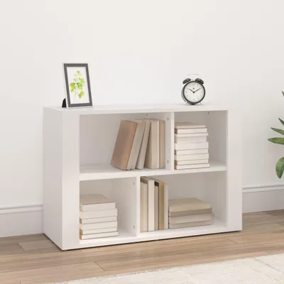 A white sideboard with books and a framed picture on top, set against a white wall and wooden floor.