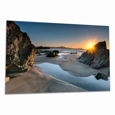 Produktbild von Wallario Herdabdeckplatte aus Glas, Größe 80 x 52 cm 1-teilig, Motiv Sonnenuntergang hinter einem Felsen am Strand