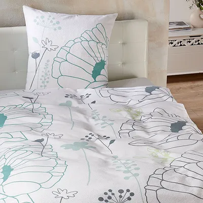 A close-up view of a floral patterned duvet cover and pillowcase set on a bed.