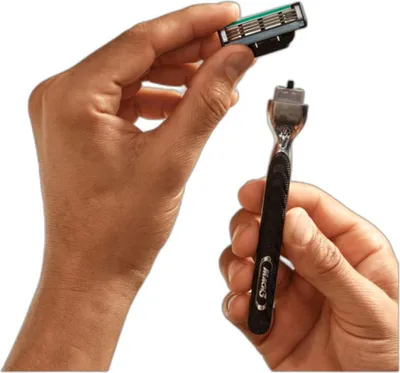 Hands holding a razor handle and a replacement blade.